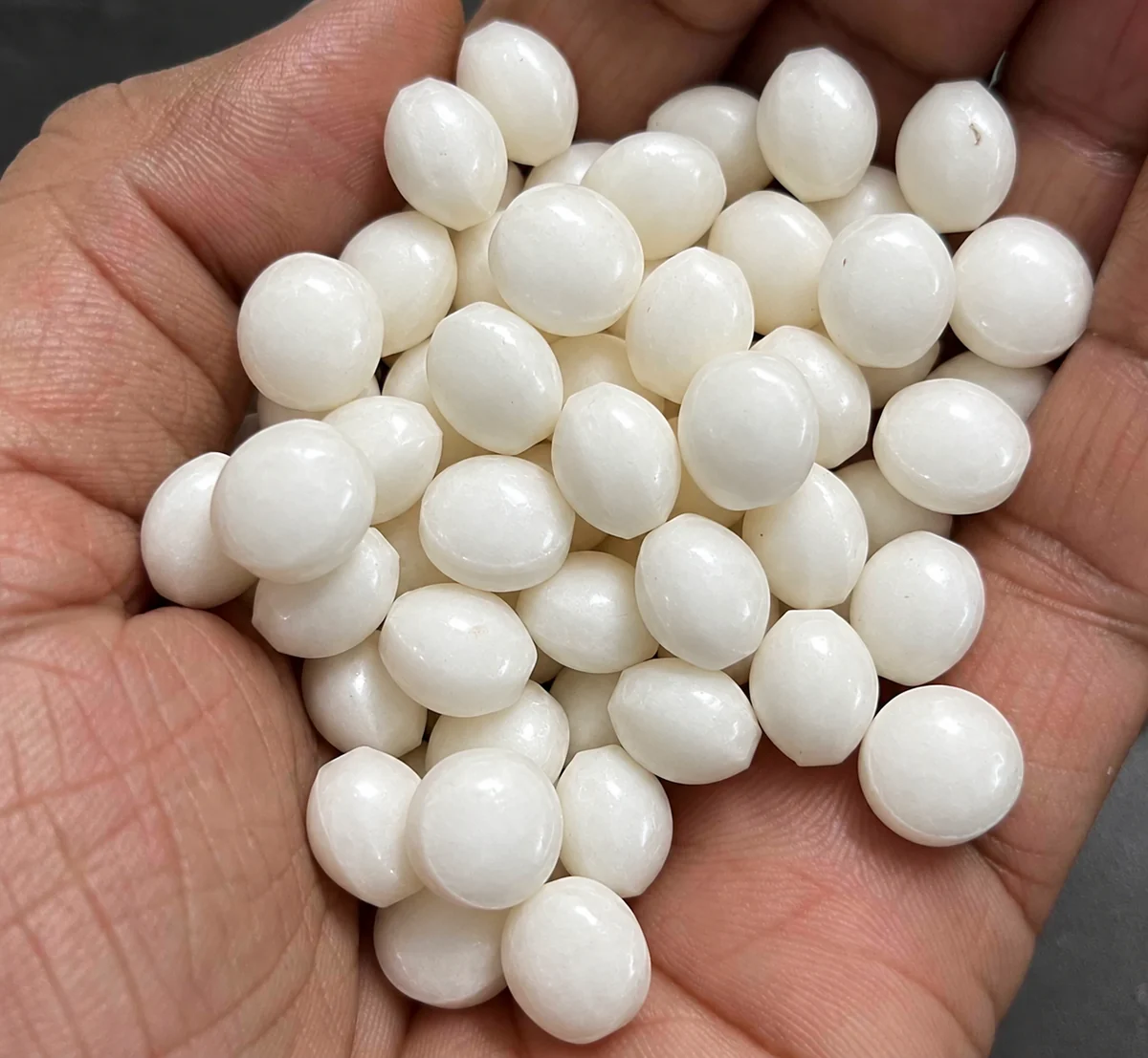 White coated urea tablets resting in the palm of a hand