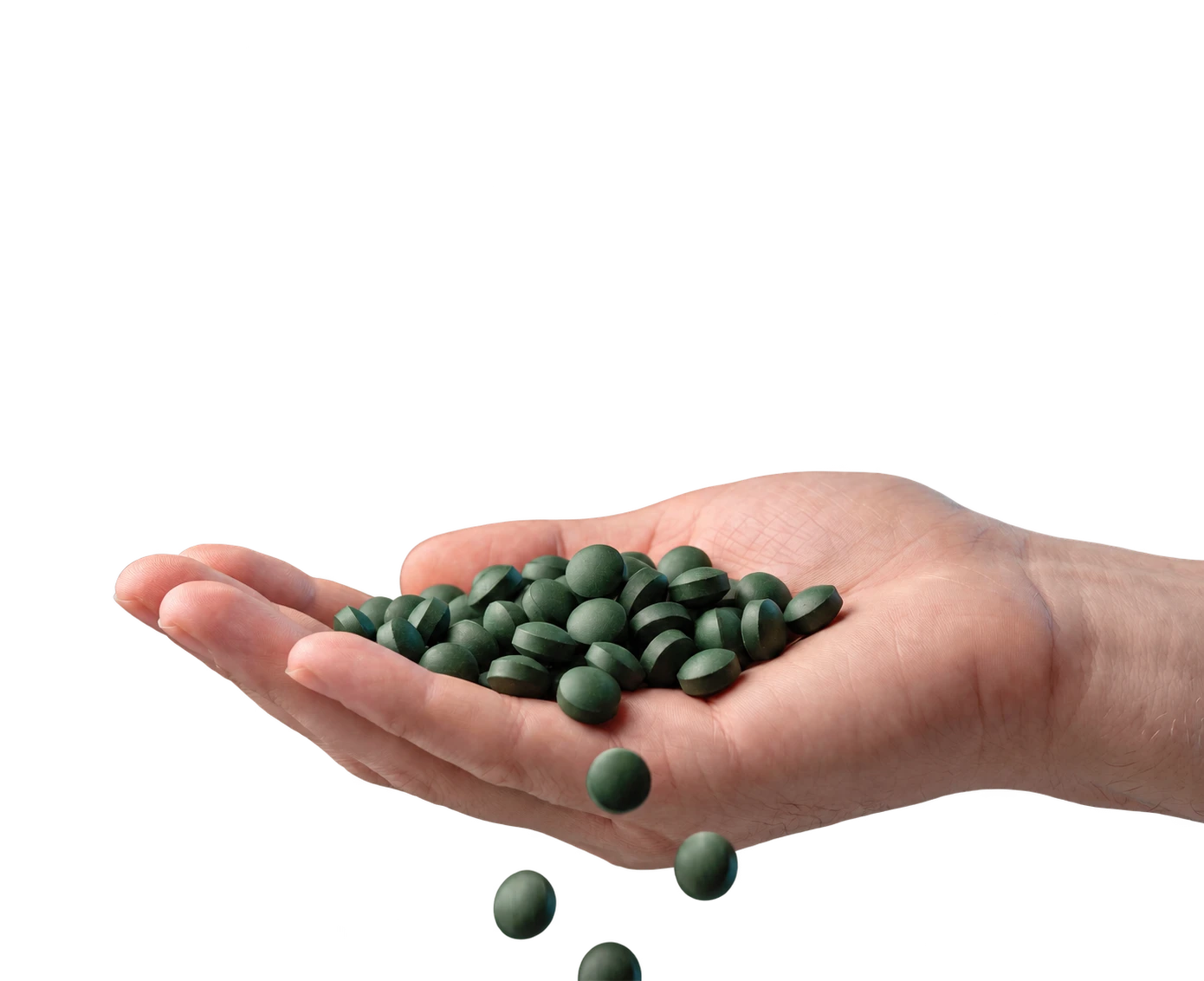 A hand holding small green polymer-coated fertilizer tablets